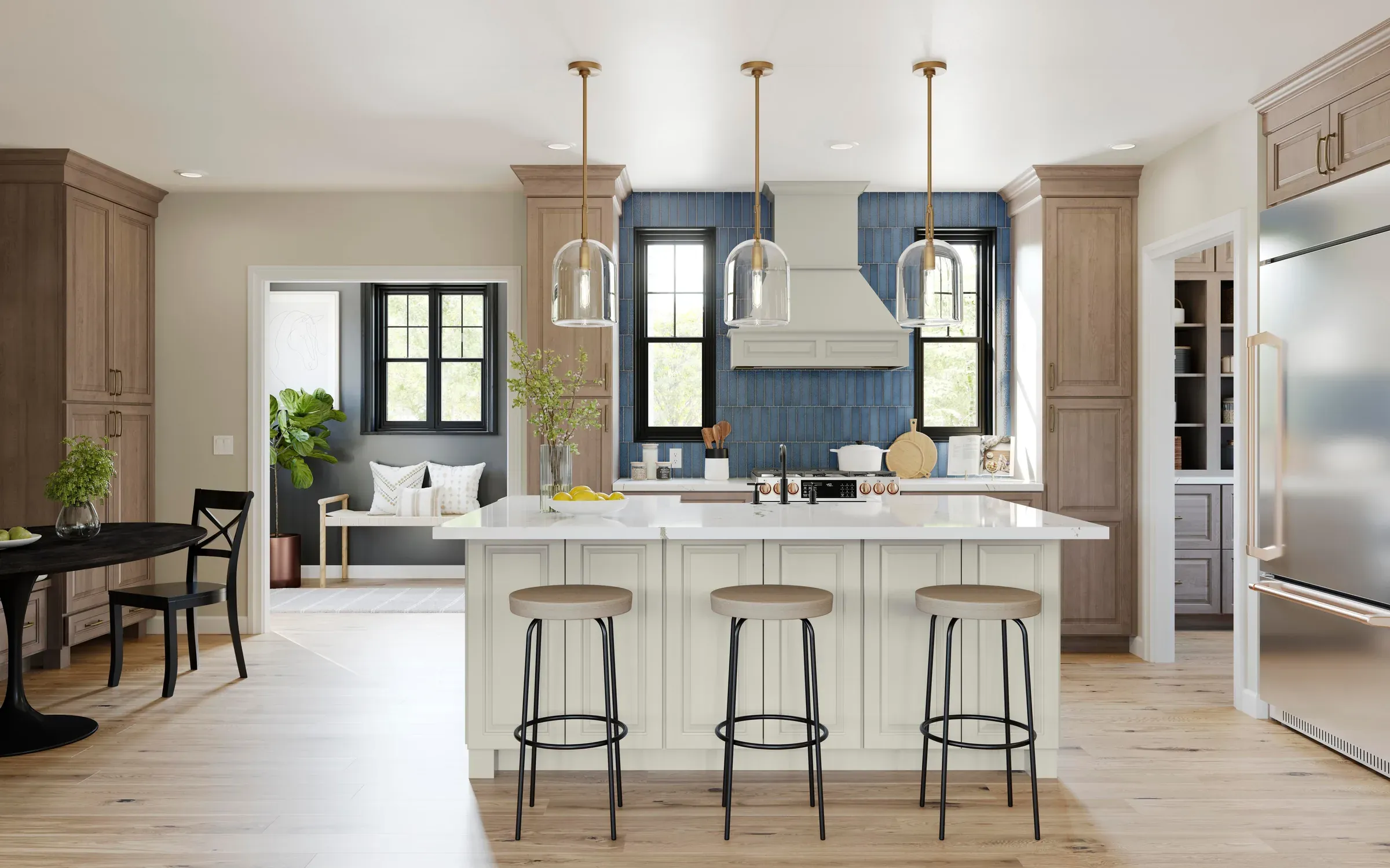 Open-plan kitchen in almond-stained maple with a painted island, brass pendants, and a blue tile backsplash.