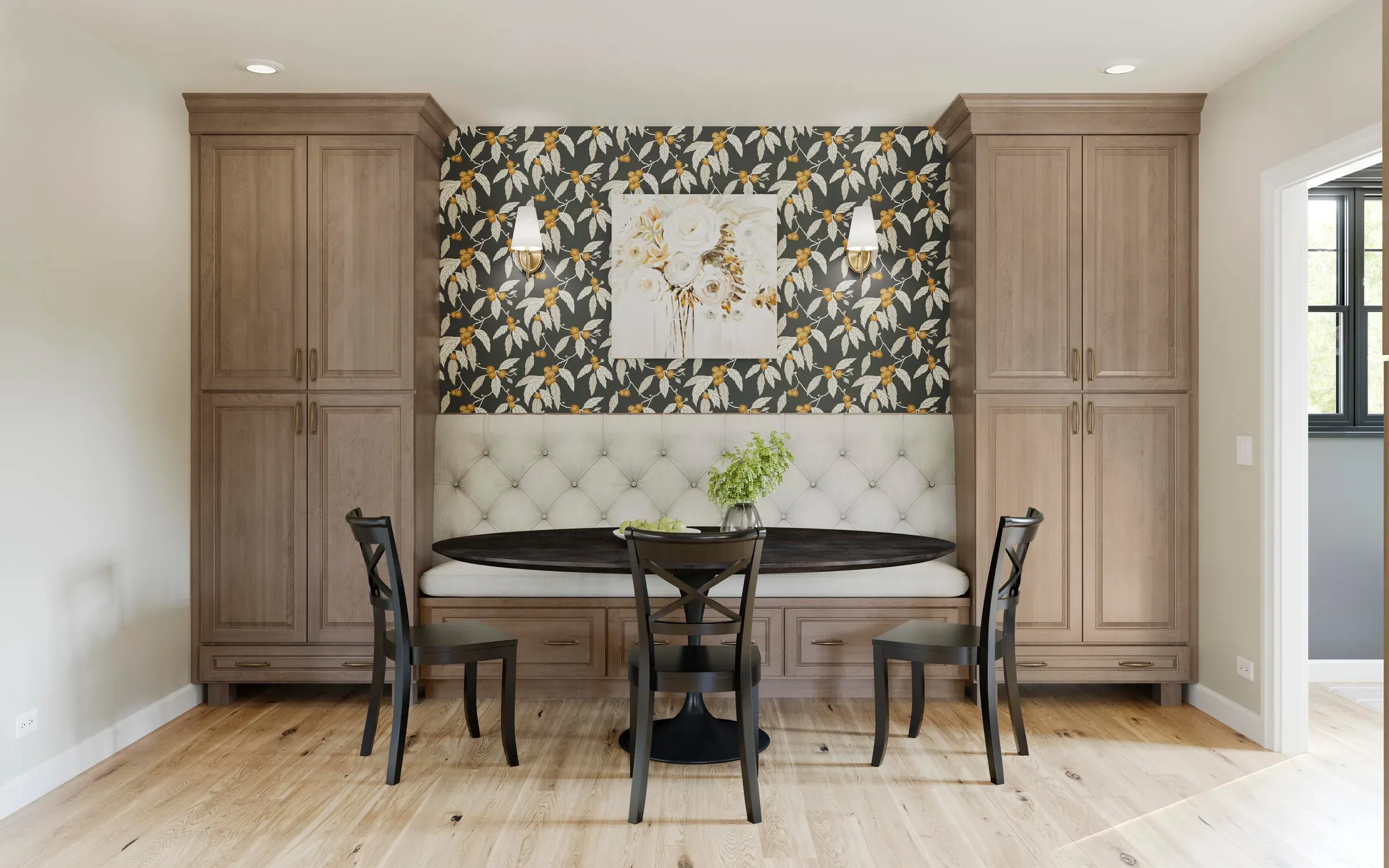 Dining nook framed by two tall almond maple cabinets, with a round table and tufted banquette.