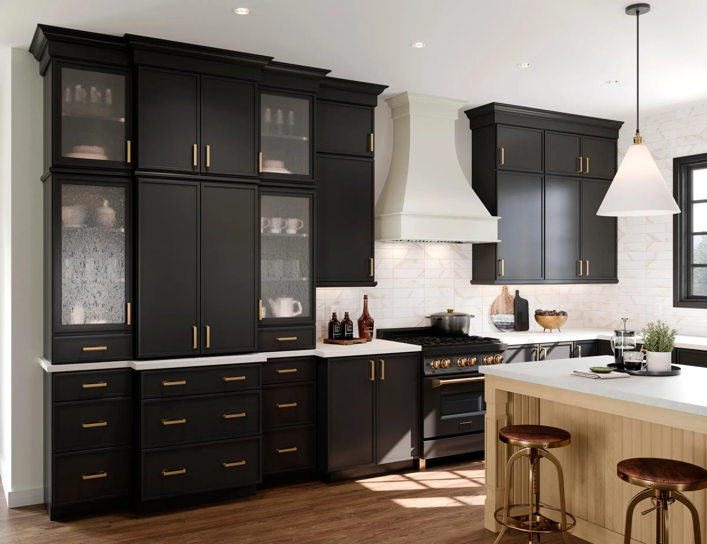 Full-height black cabinet wall with glass fronts and brass pulls, alongside a rye maple island.