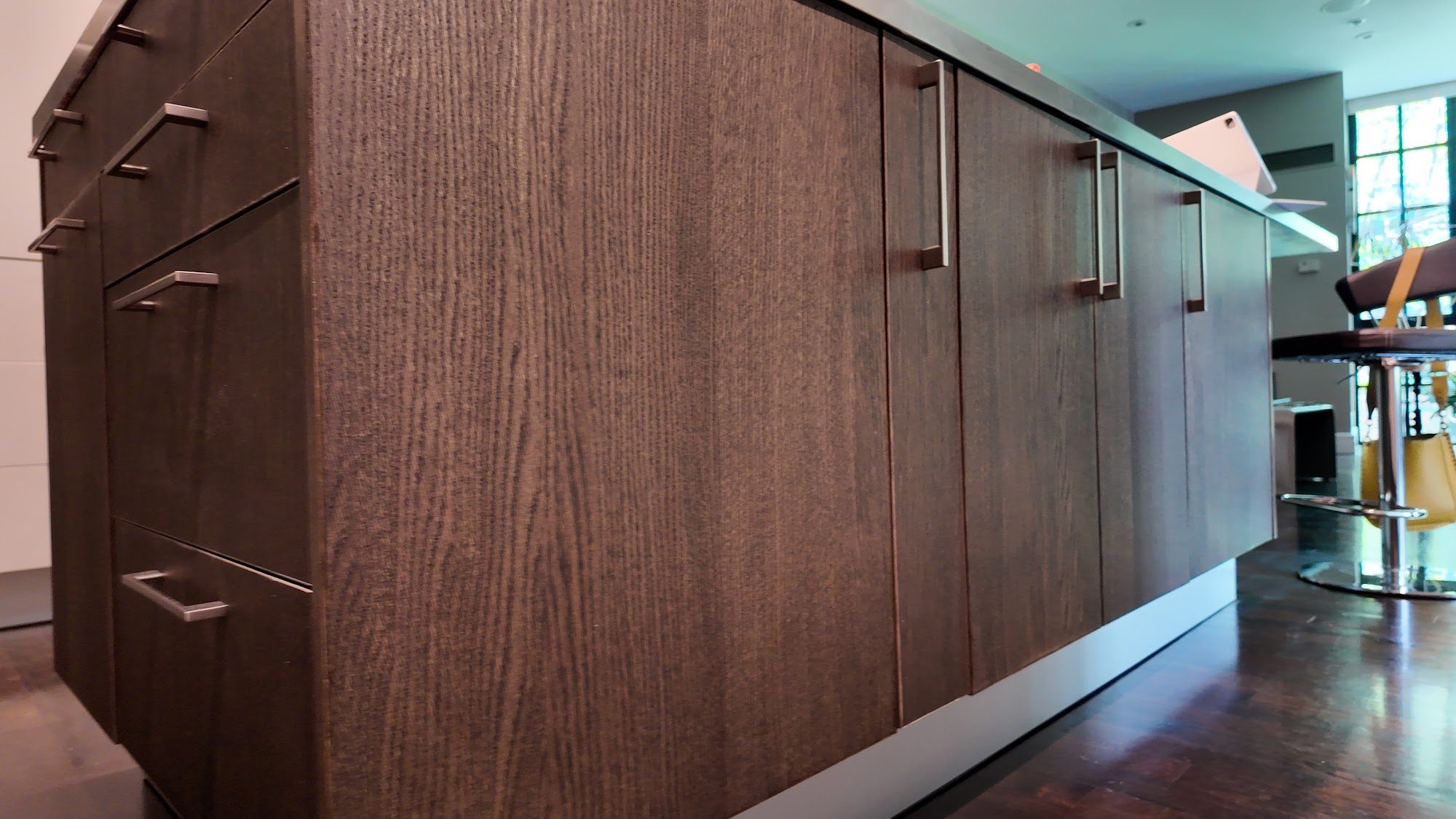 Walnut veneer lower cabinet detail, grain matched across the full run.