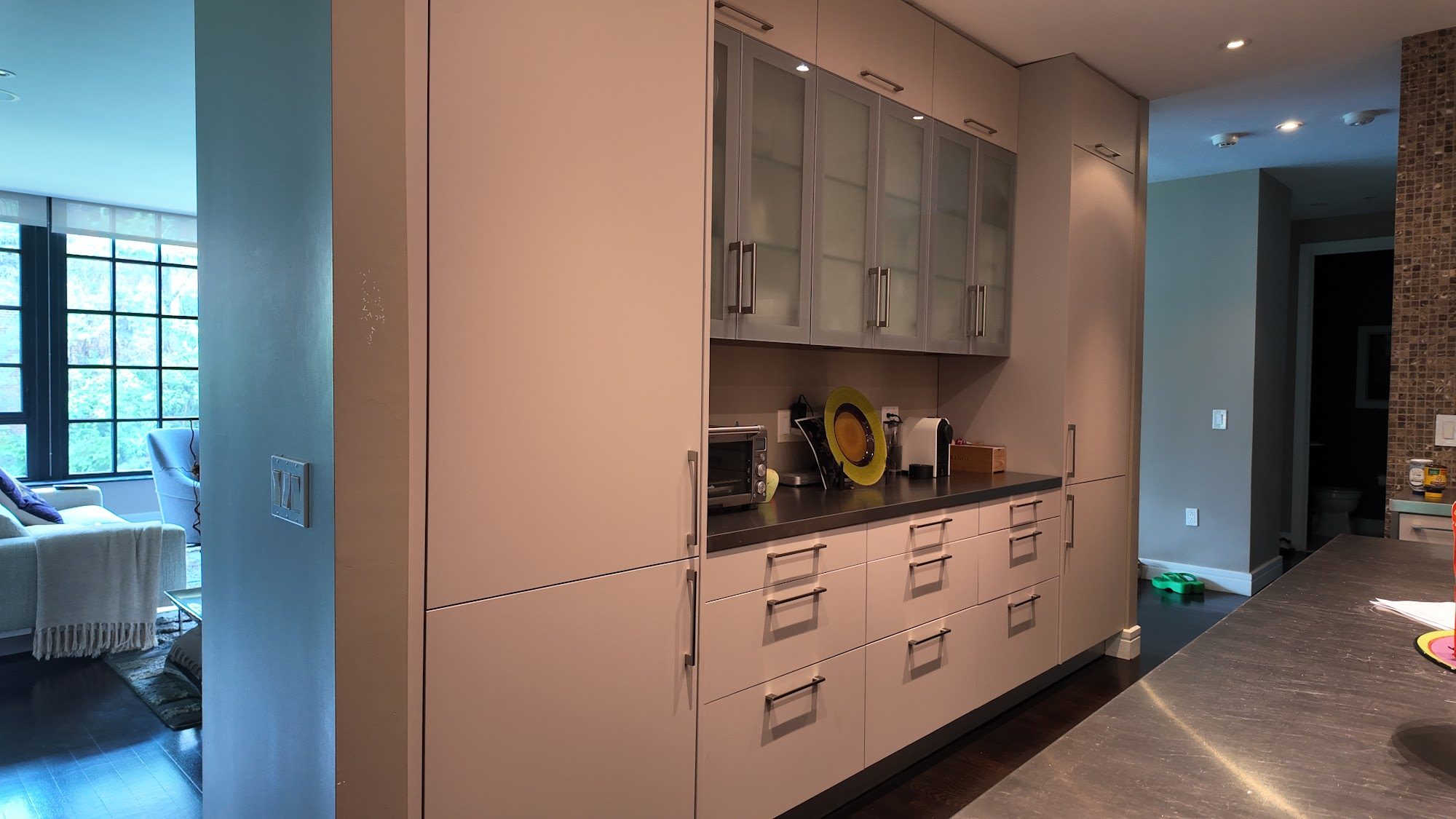 Full kitchen view showing the walnut lowers and painted glass-front uppers.